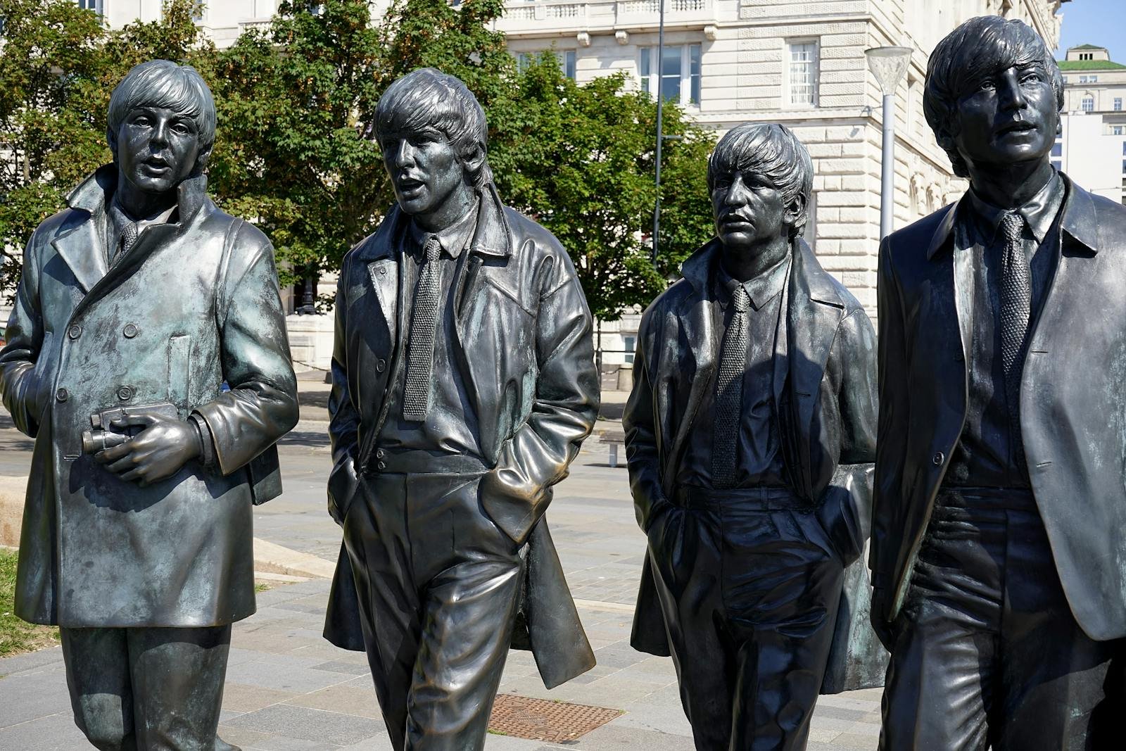 Bronze statues of The Beatles in Liverpool's city center, capturing iconic rock band imagery.